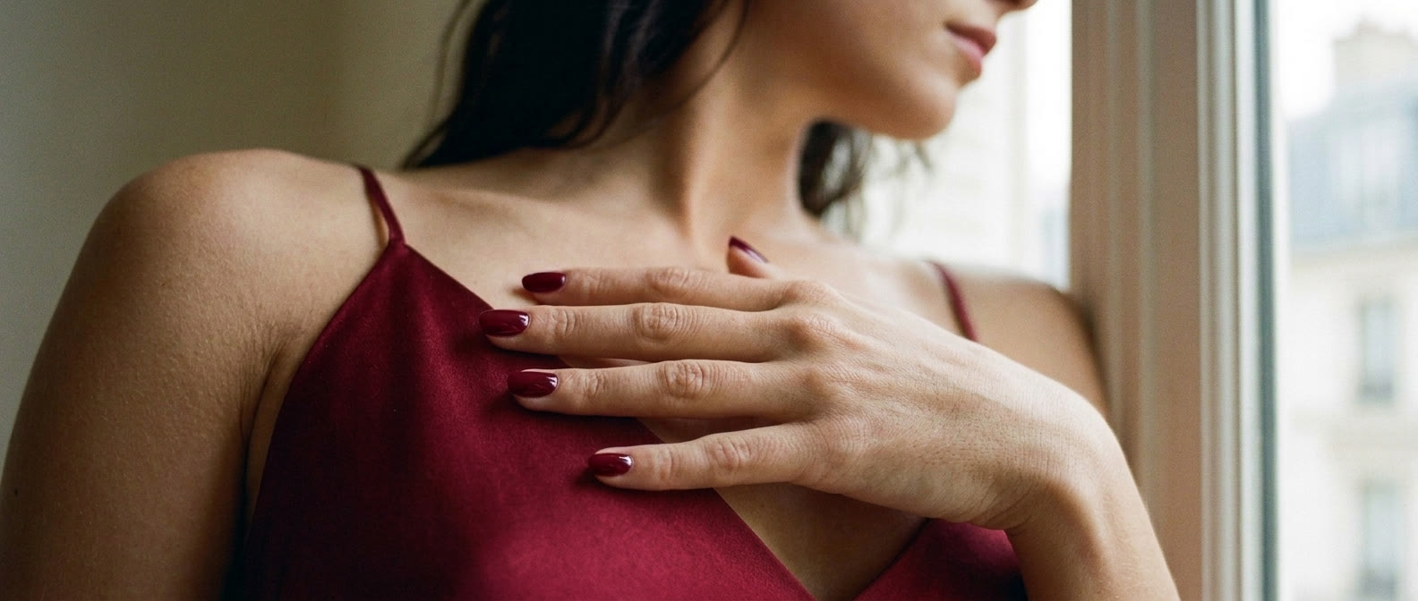In the red dress at the window, her nails the same red